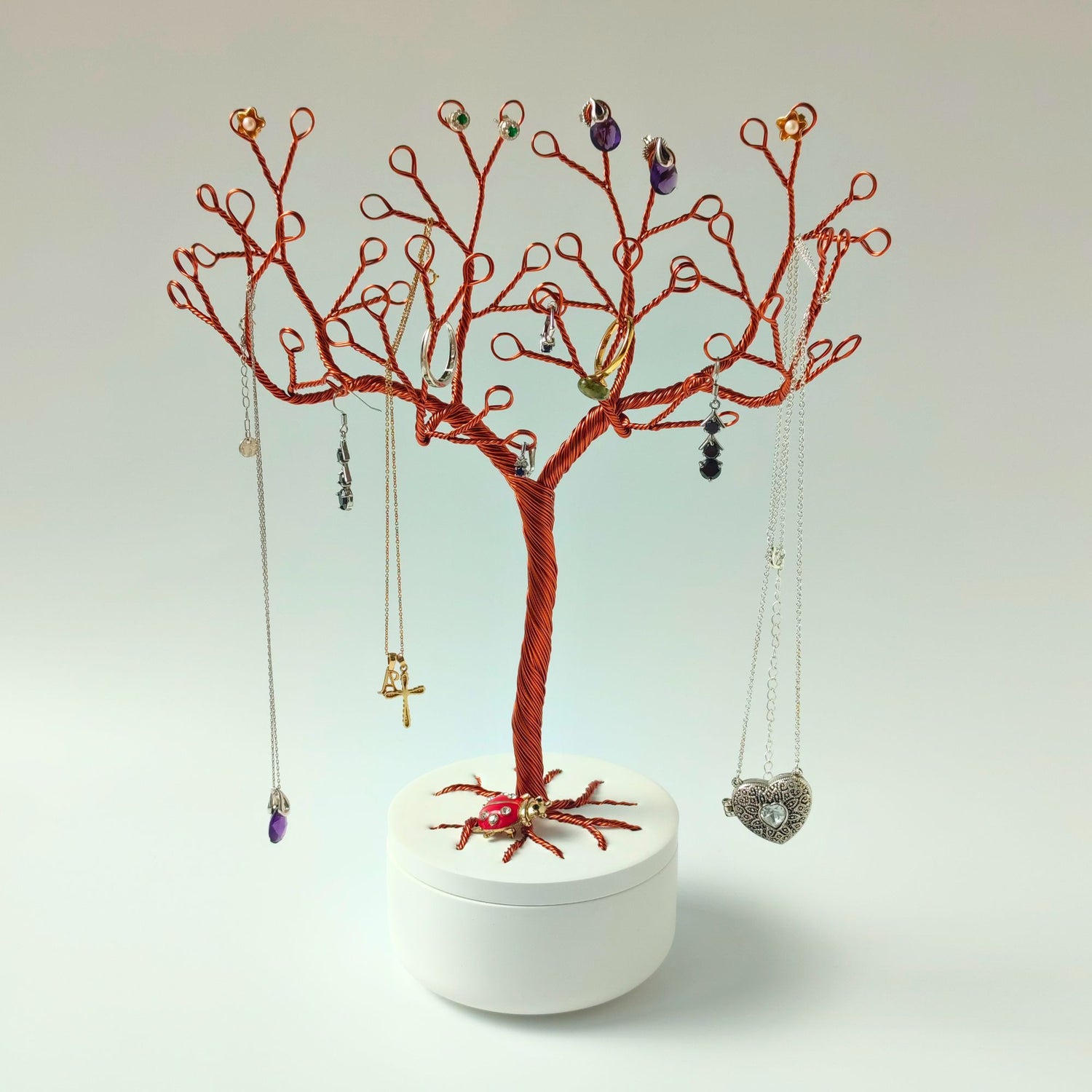 Copper jewelry tree stand displaying rings, earrings and necklaces