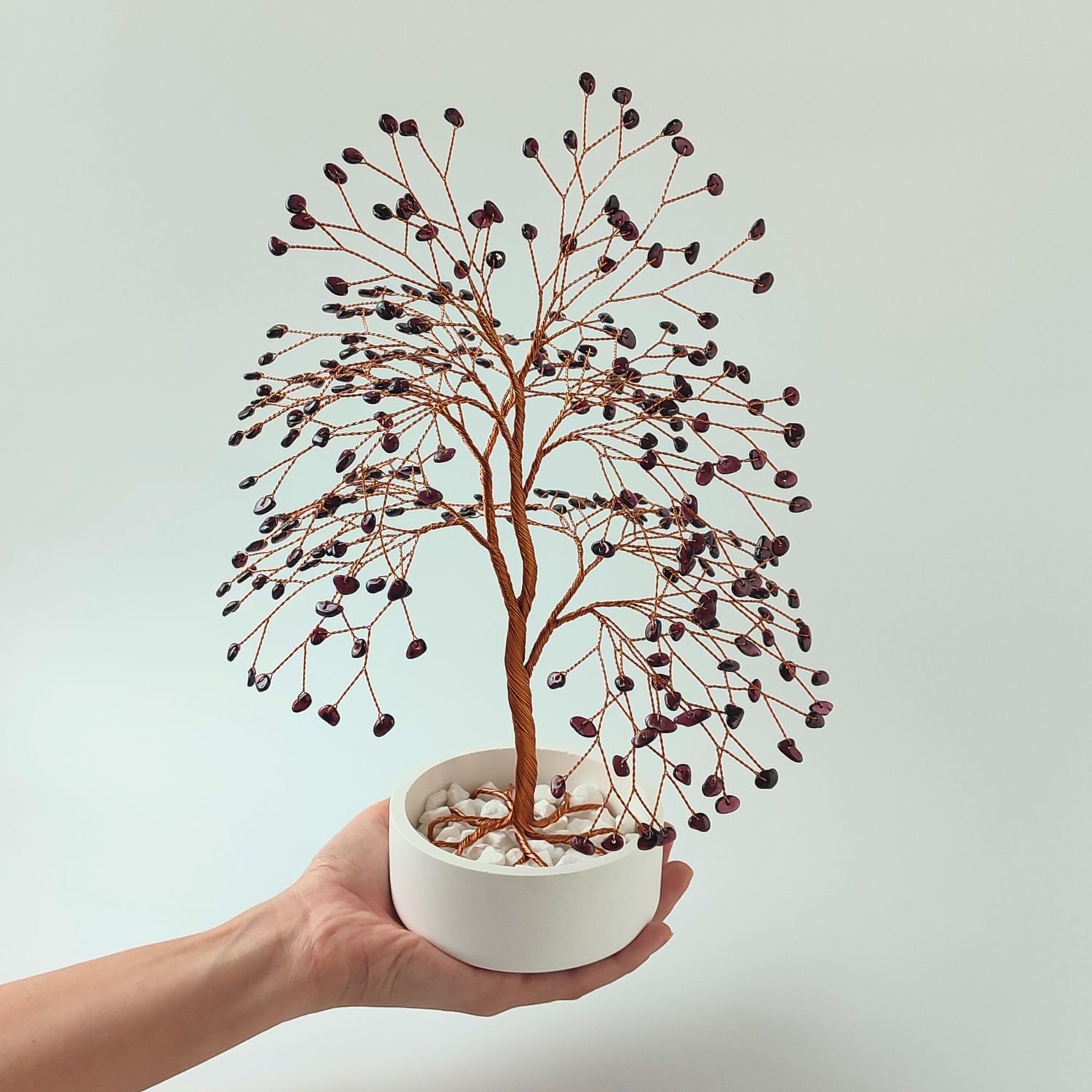 Garnet gemstone copper large tree with decorative stones shown in hand to show size and proportion