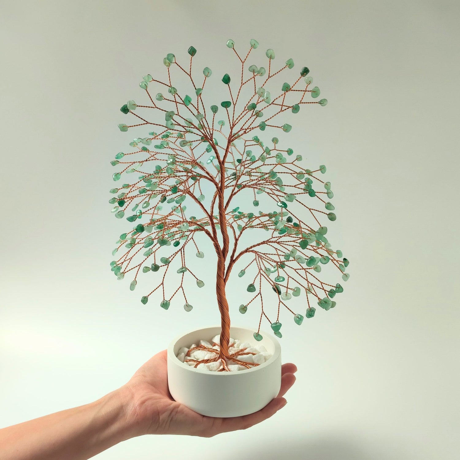 Green aventurine gemstone copper large tree with decorative stones shown in hand to show size and proportion