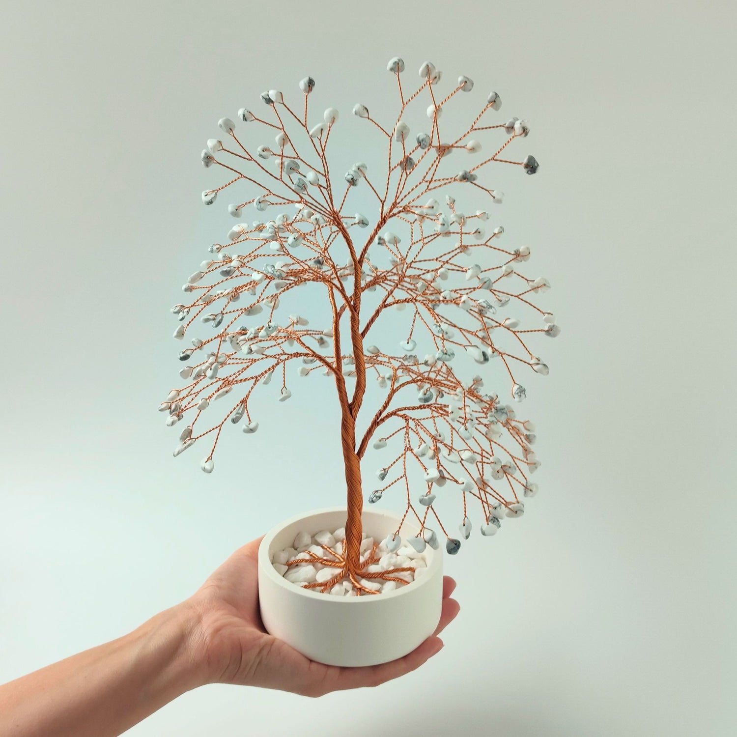 Howlite gemstone copper large tree with decorative stones shown in hand to show size and proportion