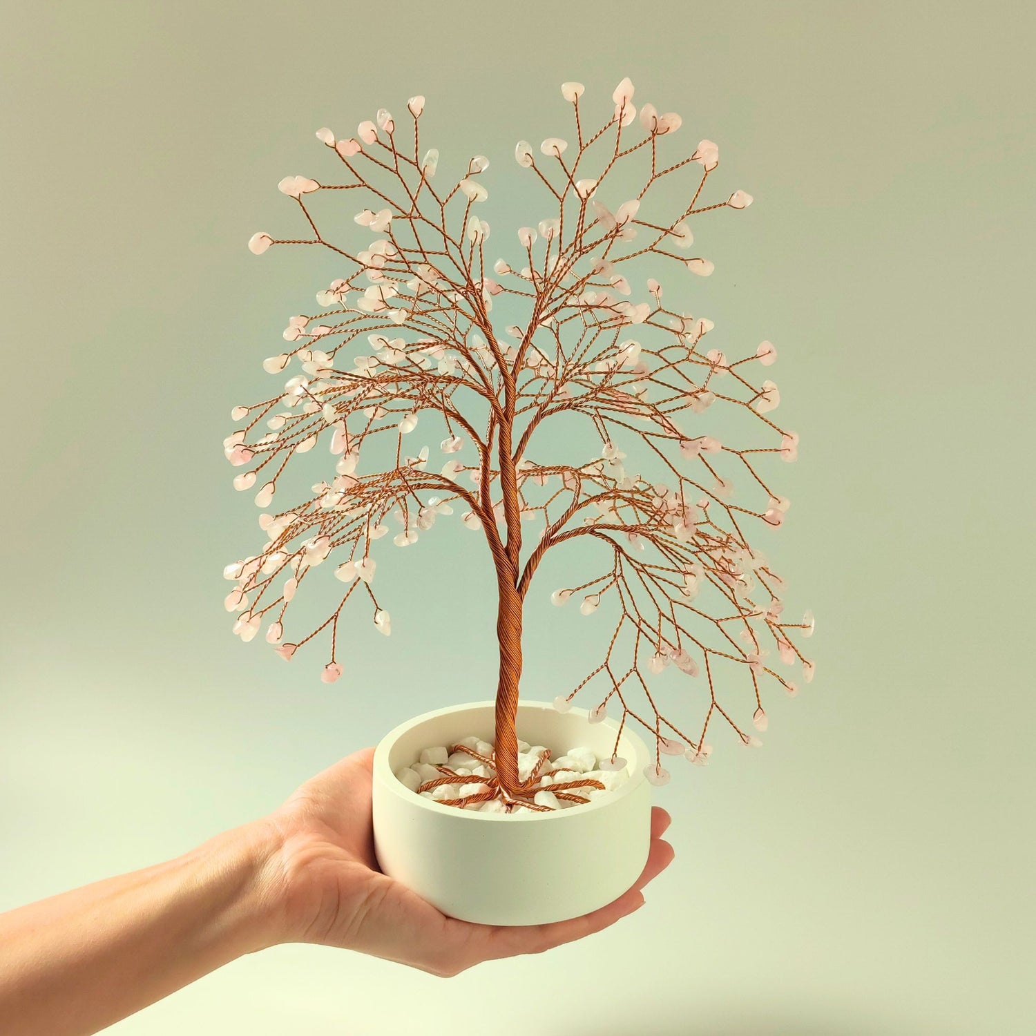 Rose quartz gemstone copper large tree with decorative stones shown in hand to show size and proportion