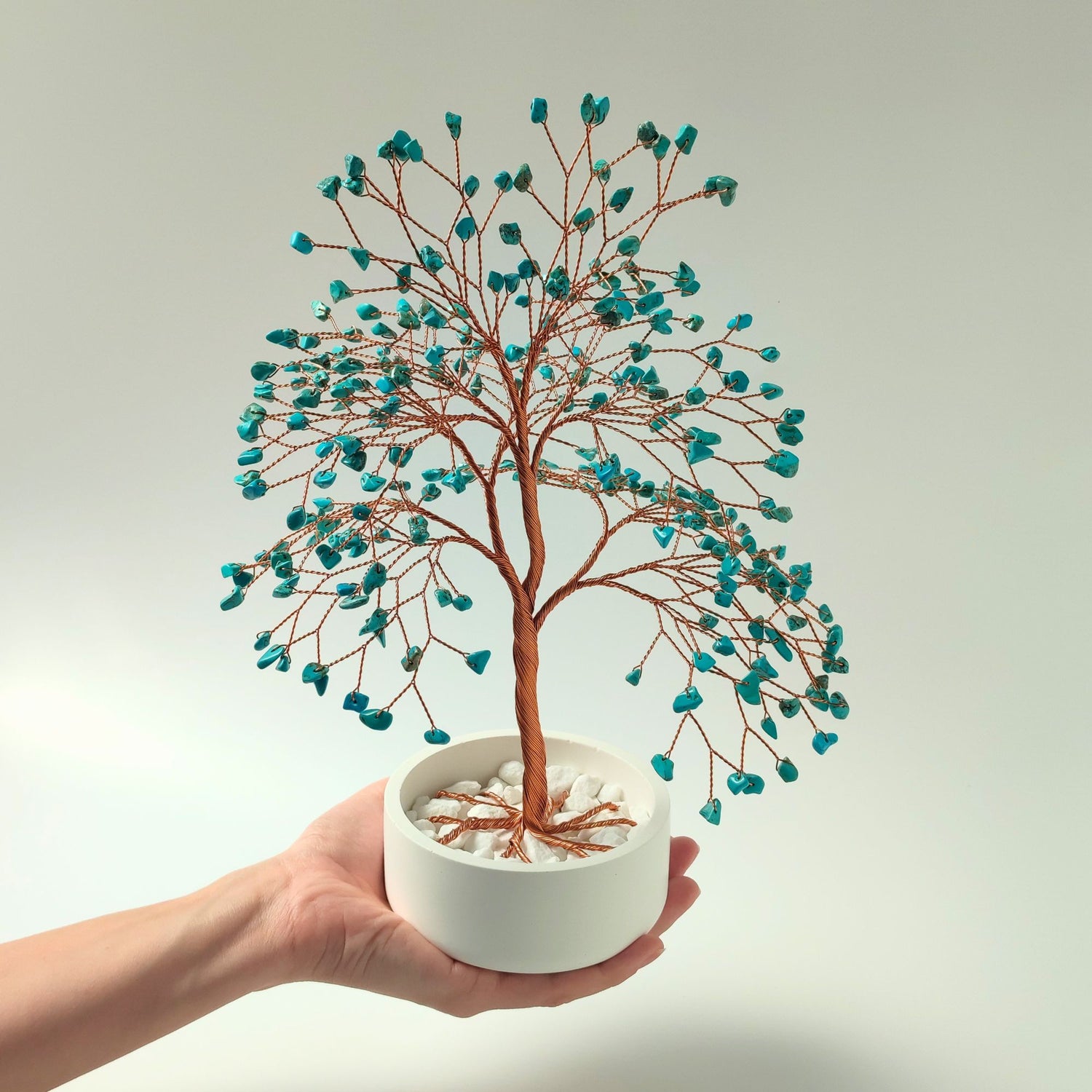 Turquoise gemstone copper large tree with decorative stones shown in hand to show size and proportion