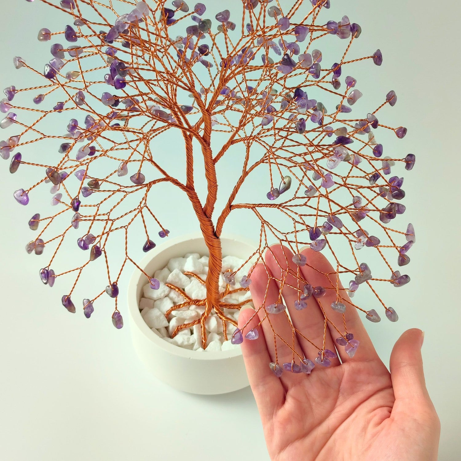 280 of amethyst crystal gemstones compared with hand to show size and proportion