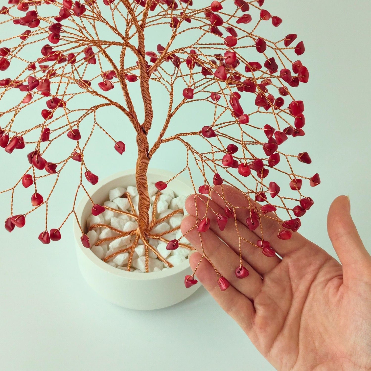 280 of coral gemstones compared with hand to show size and proportion