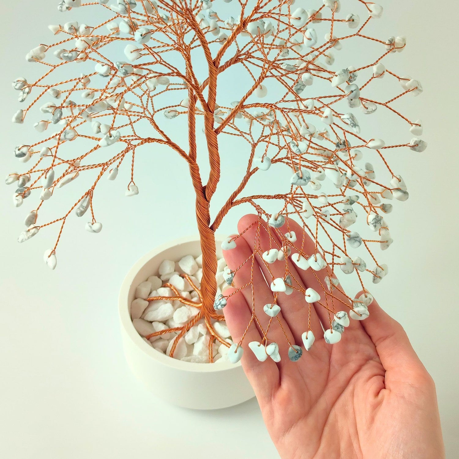 280 of howlite gemstones compared with hand to show size and proportion