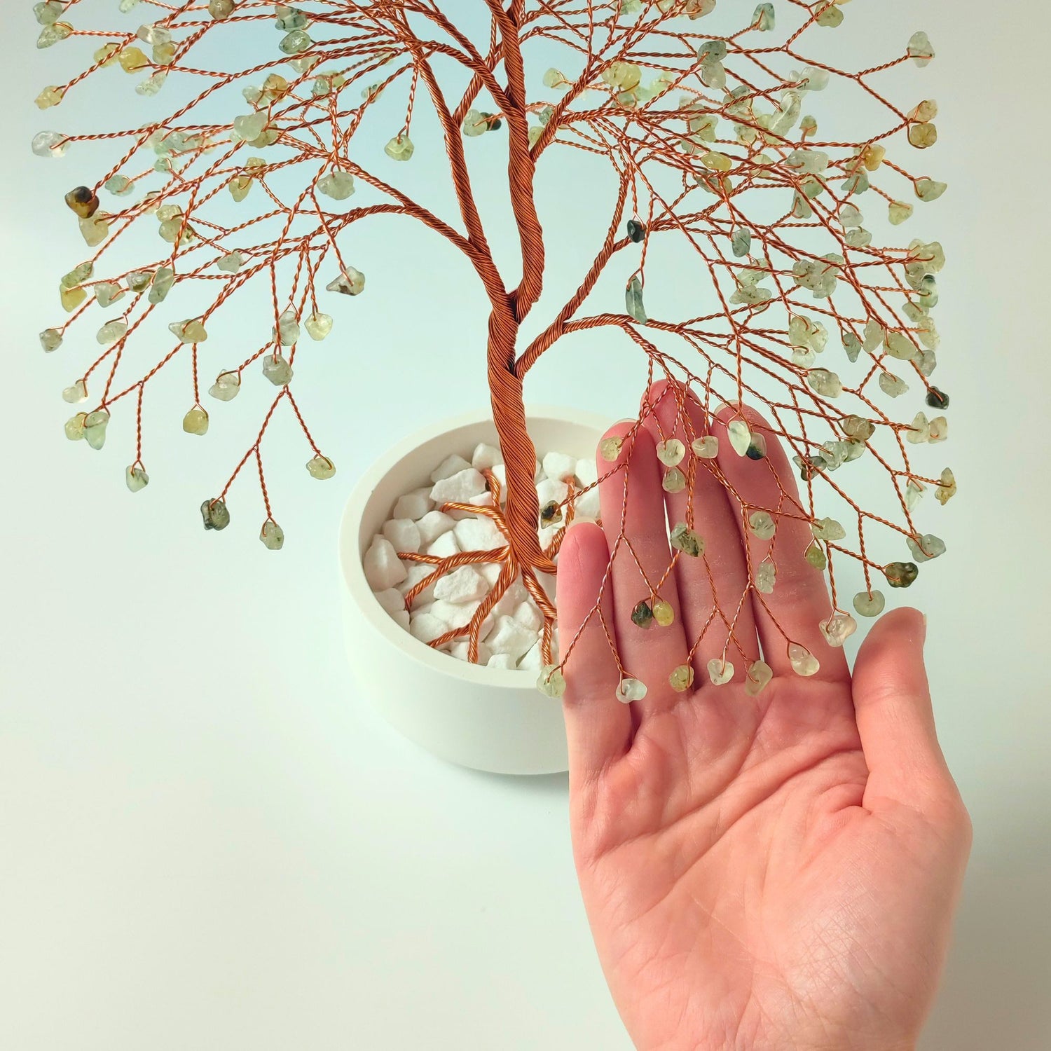 280 of prehnite gemstones compared with hand to show size and proportion