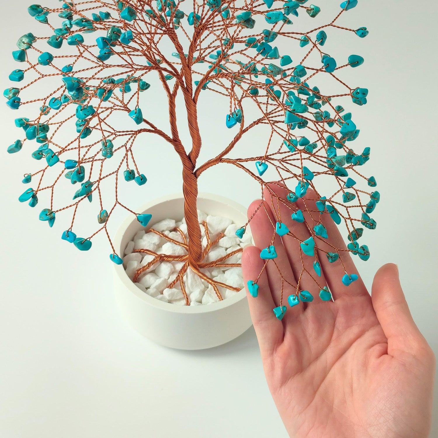 280 of turquoise gemstones compared with hand to show size and proportion