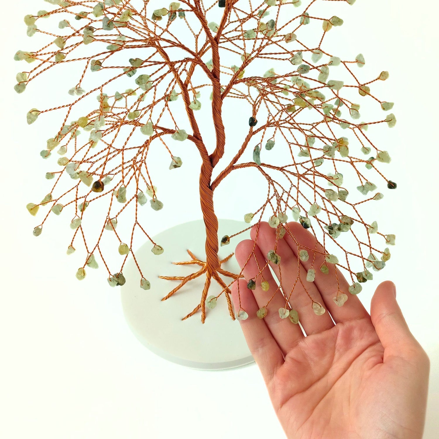 Handmade decorative tree with small stones on a white background