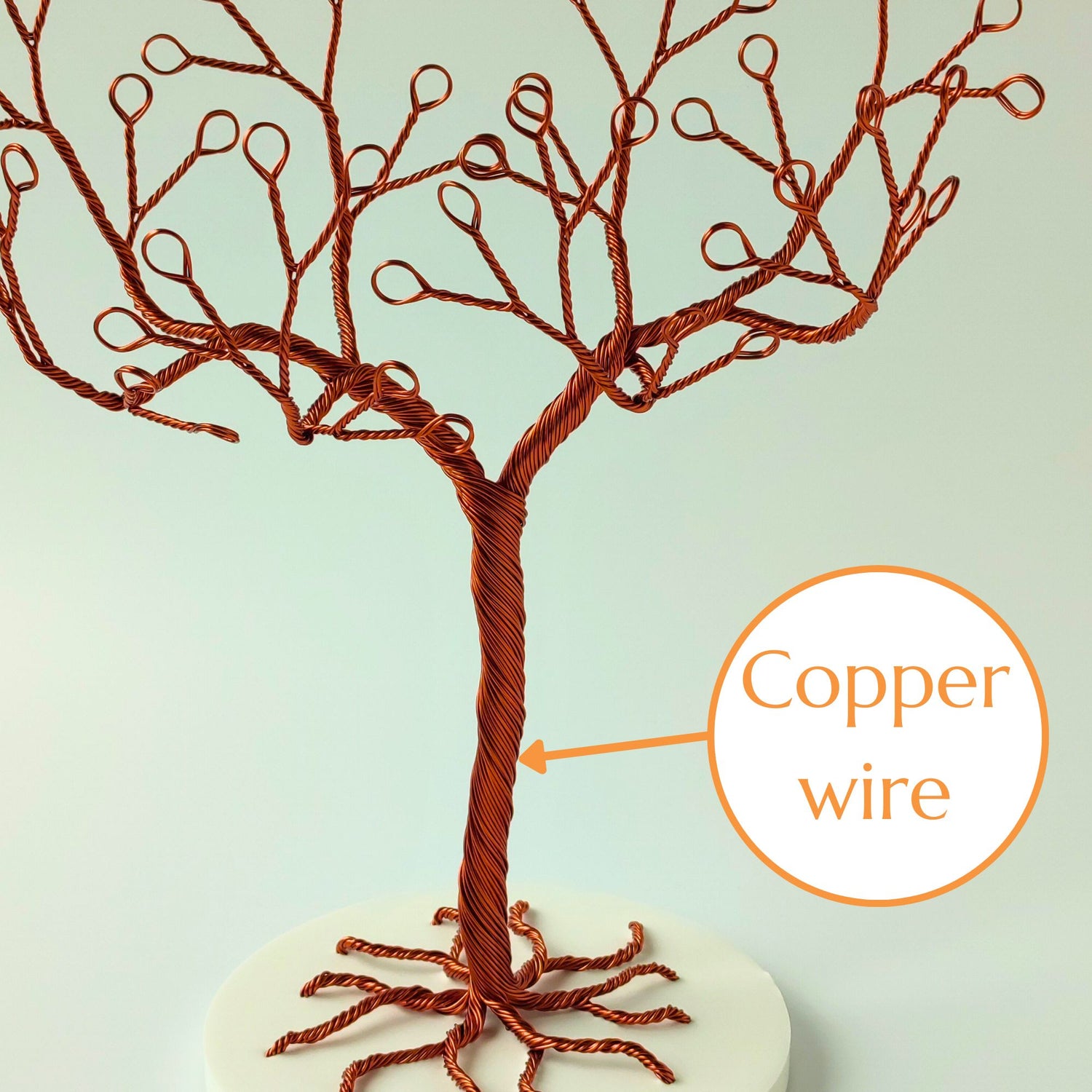 Close-up of copper wire jewelry stand trunk with material annotation and tray