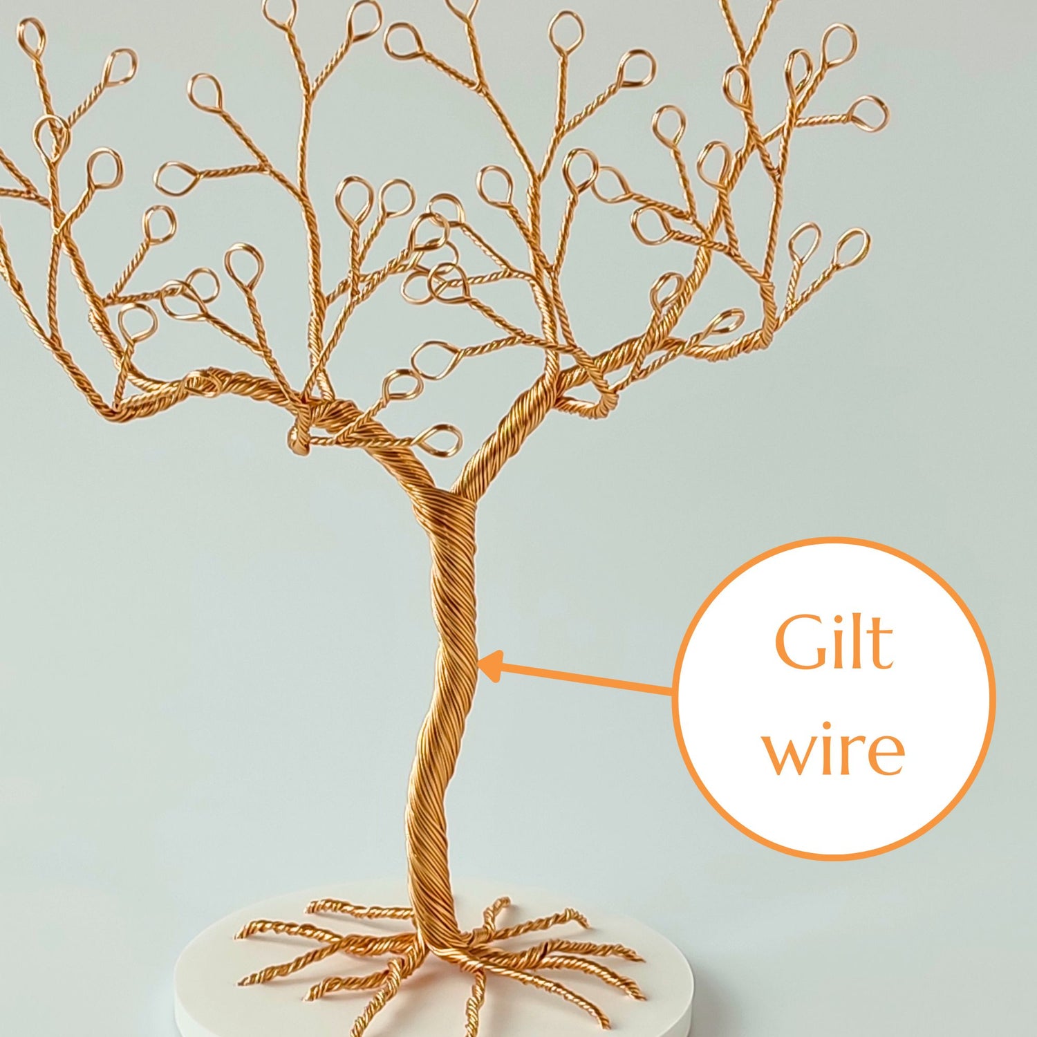 Close-up of gilt wire jewelry stand trunk with material annotation and tray