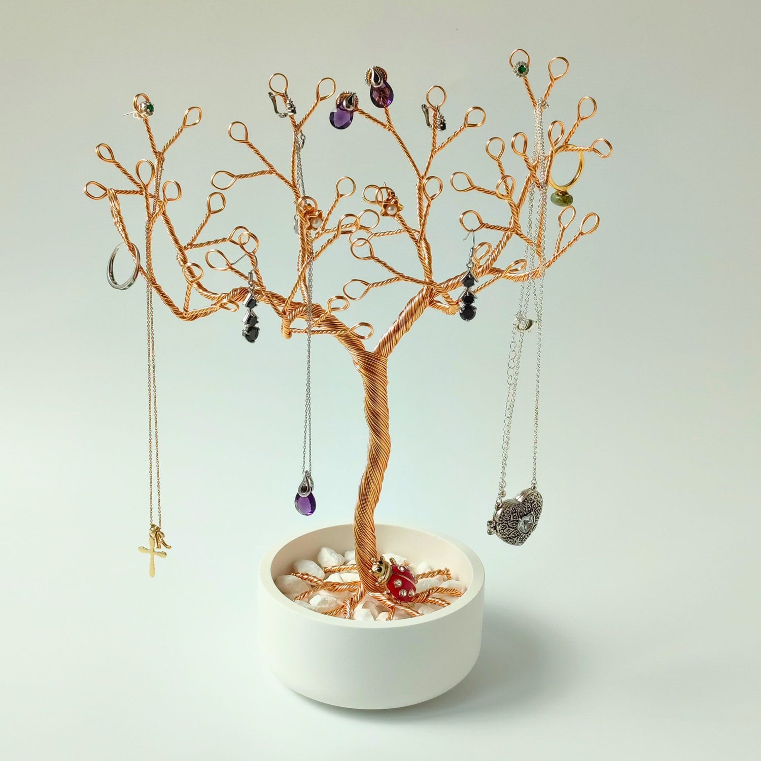 Jewelry tree made of gilt wire in bowl with white stones