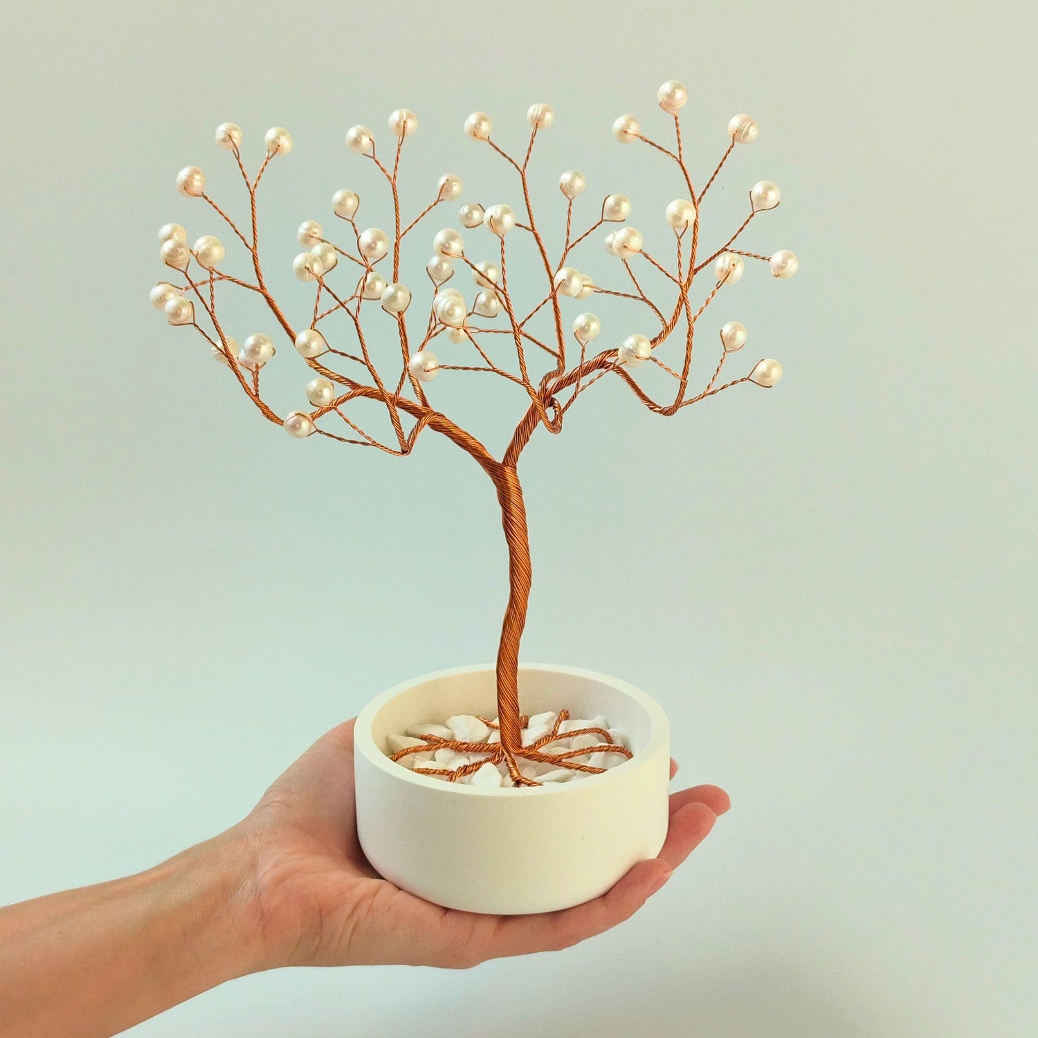 Freshwater white pearl copper elegant tree with decorative stones shown in hand to show size and proportion