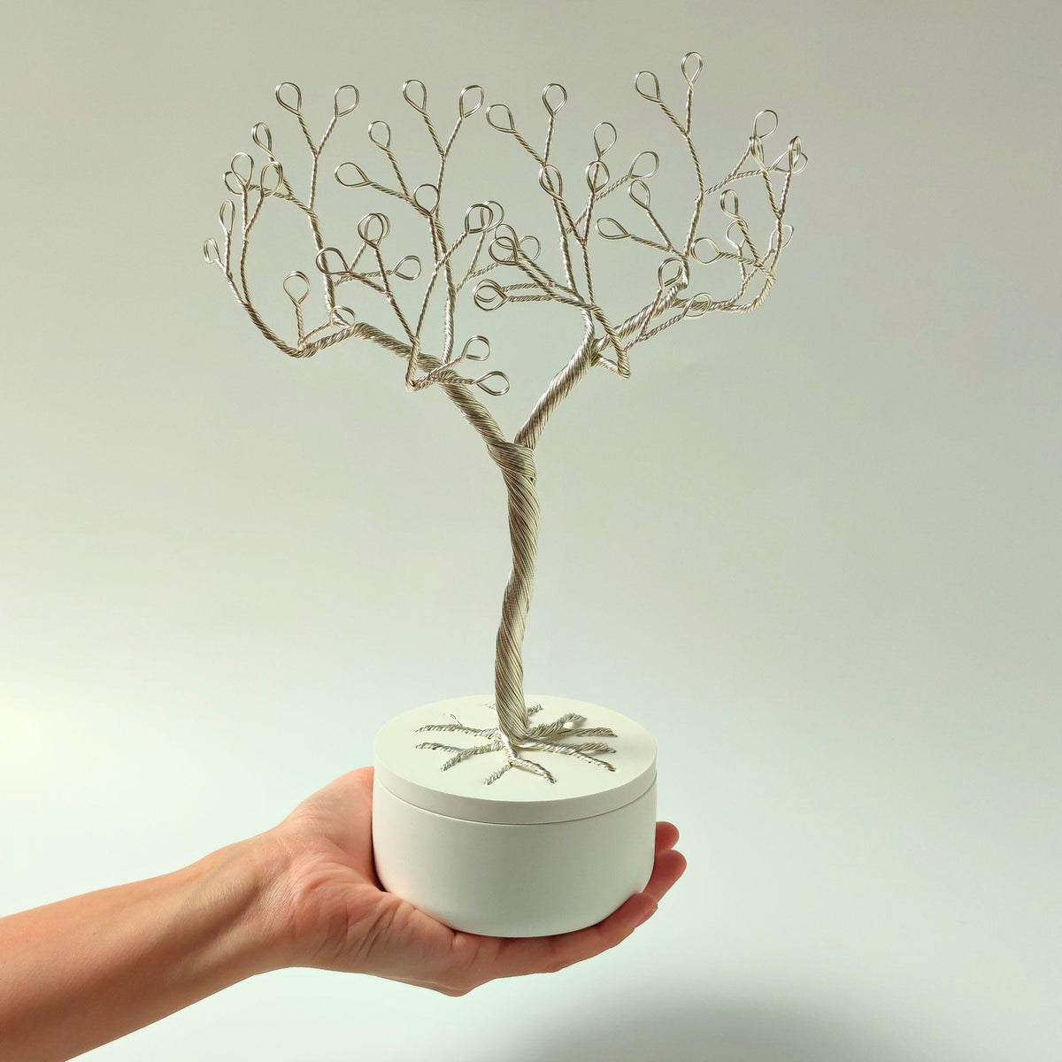 Silver jewelry tree held in a hand to show its size