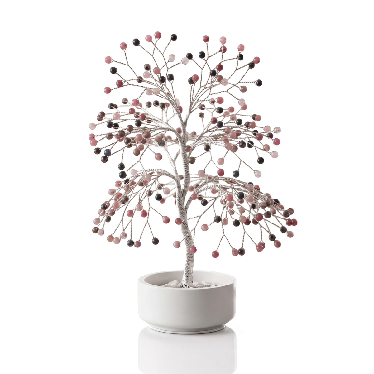 Silver-plated wire tree with polished pink thulite beads in a white ceramic bowl