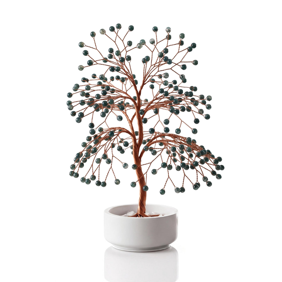 Copper wire tree with polished forest green moss agate spheres in a plain white ceramic bowl