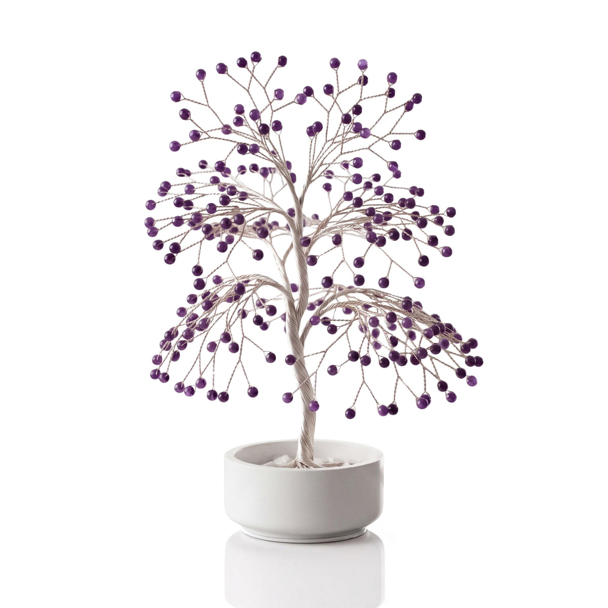 Silver-plated wire tree with polished deep purple amethyst spheres in a white ceramic bowl