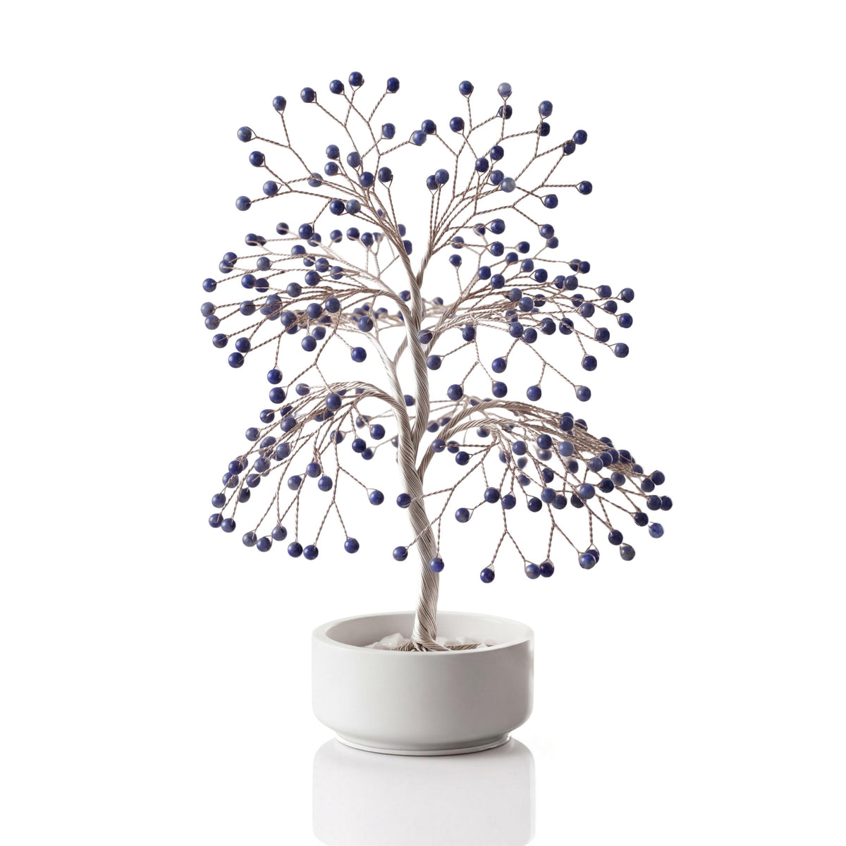 Silver-plated wire tree with polished royal blue lapis lazuli spheres in a white ceramic bowl