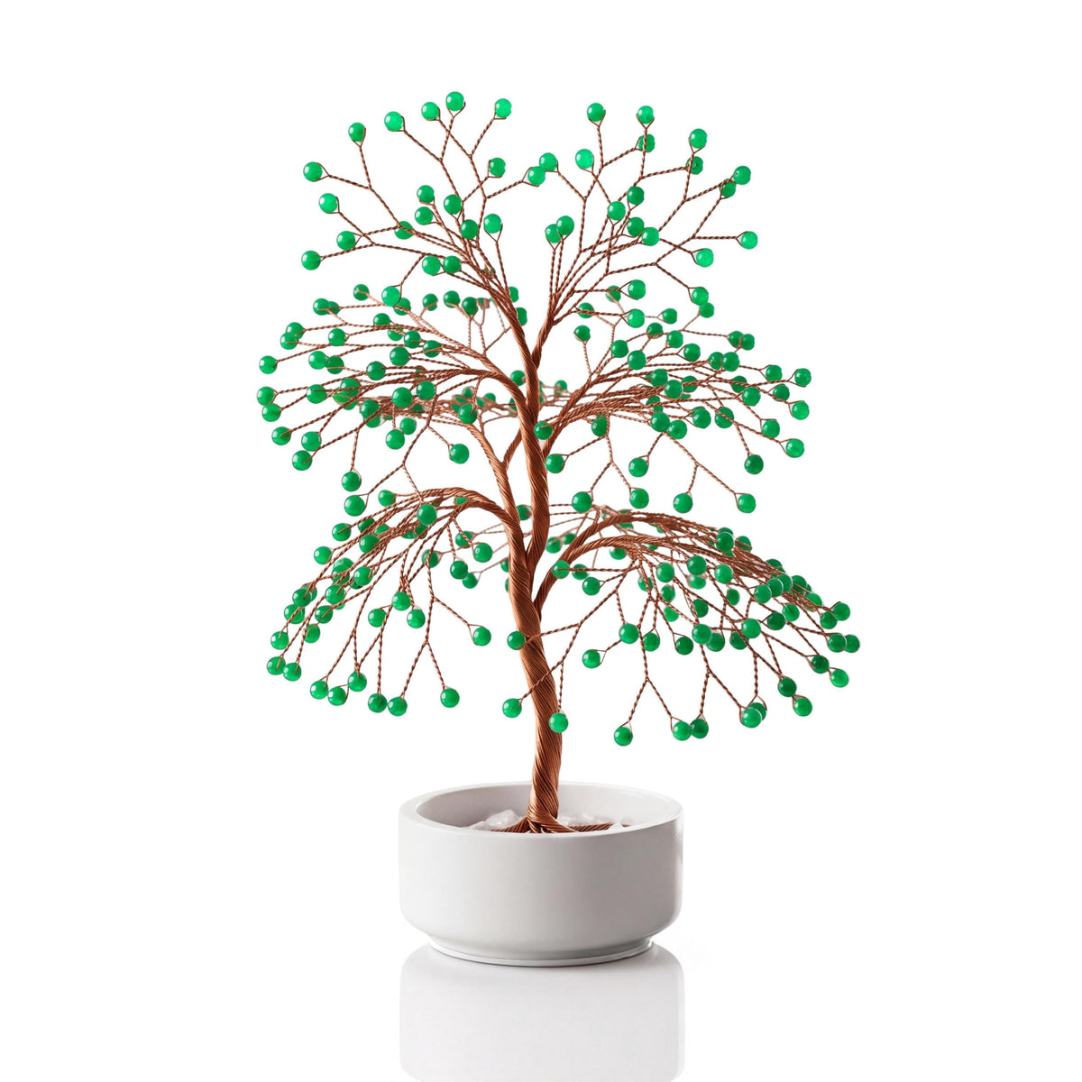 Copper wire tree with polished fresh green aventurine spheres in a plain white ceramic bowl