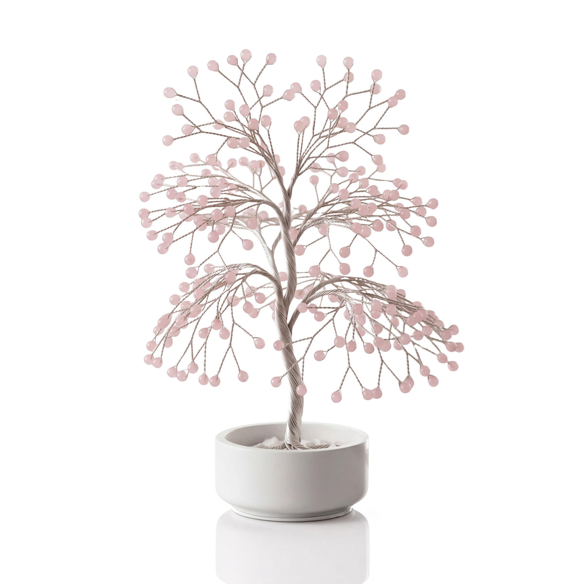Silver-plated wire tree with polished pale pink rose quartz spheres in a white ceramic bowl