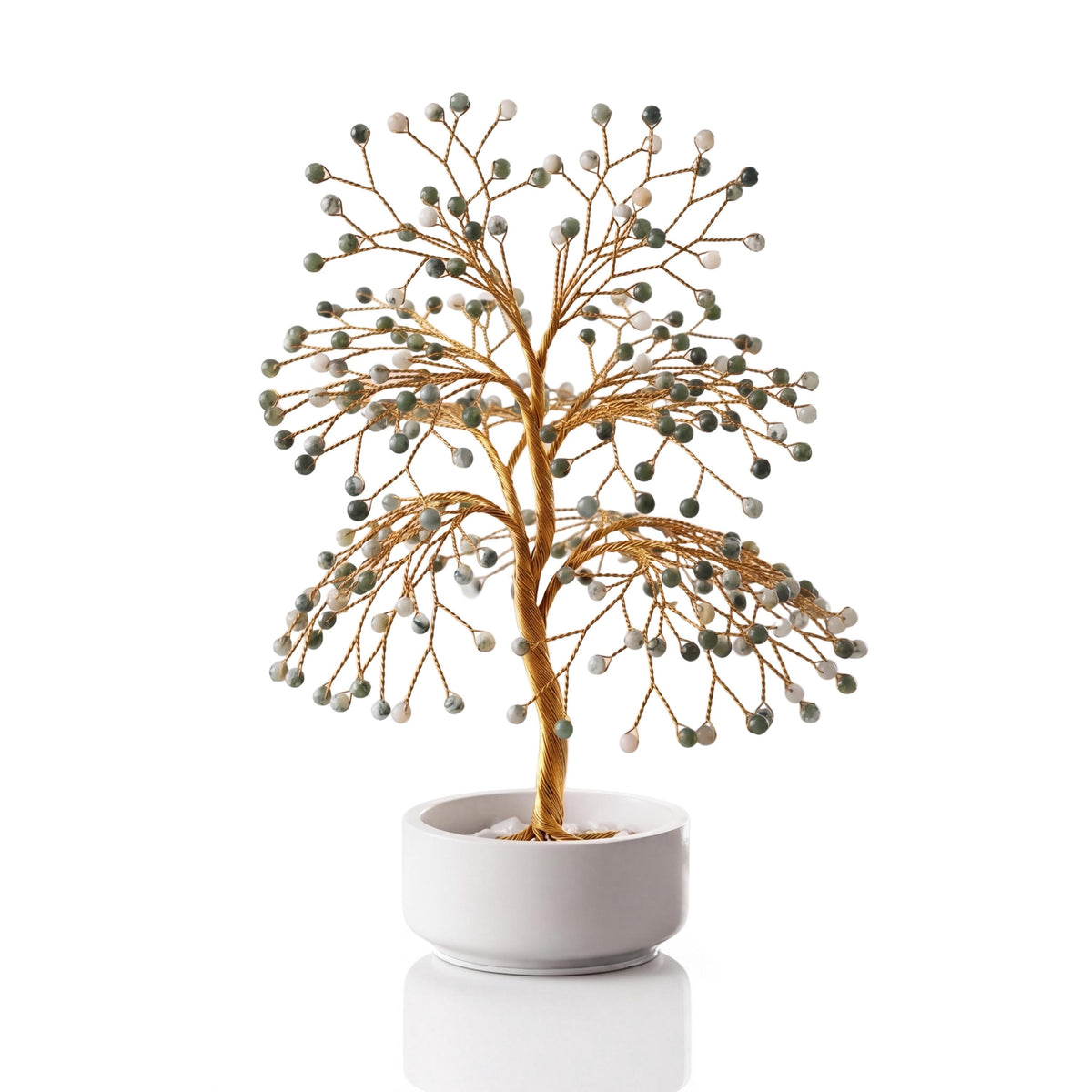 Gold-plated wire tree with polished white and green tree agate beads in a white ceramic bowl