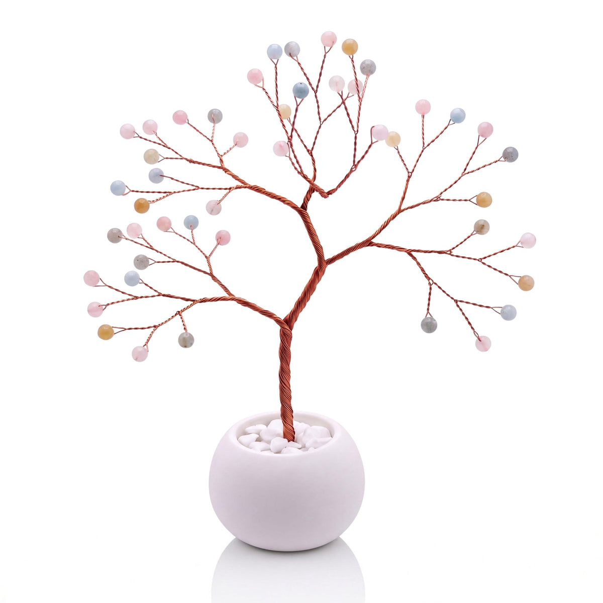 Copper wire tree with polished pastel pink, blue and honey beryl beads in a plain white bowl filled with white pebbles