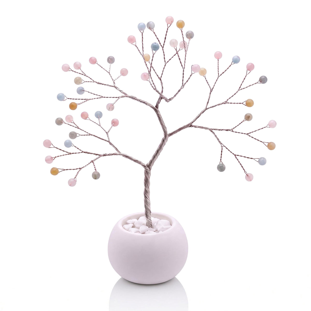 Silver-plated wire tree with polished pastel pink, blue and honey beryl beads in a white bowl with white pebbles