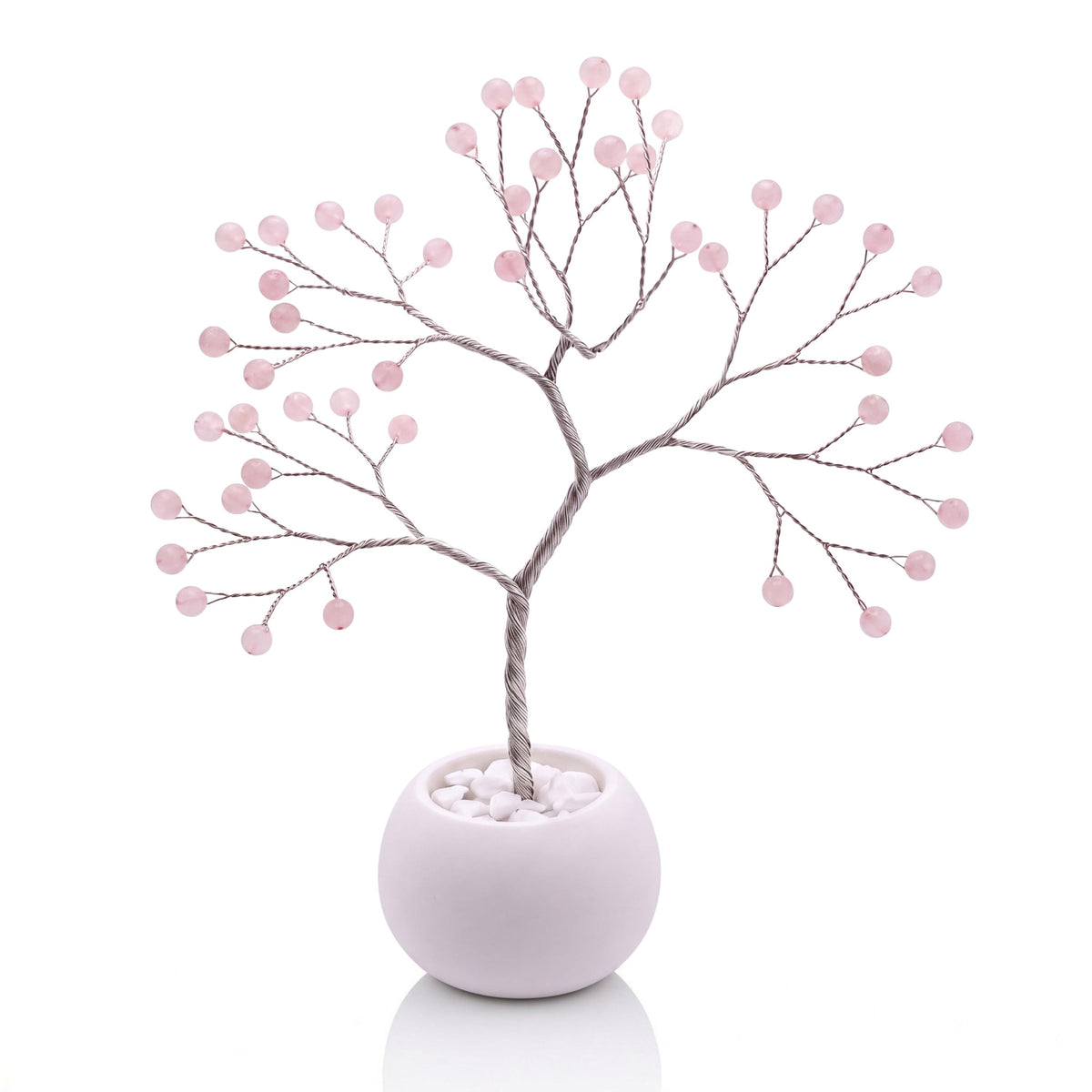 Silver-plated wire tree with polished soft pink rose quartz beads in a white bowl with white pebbles