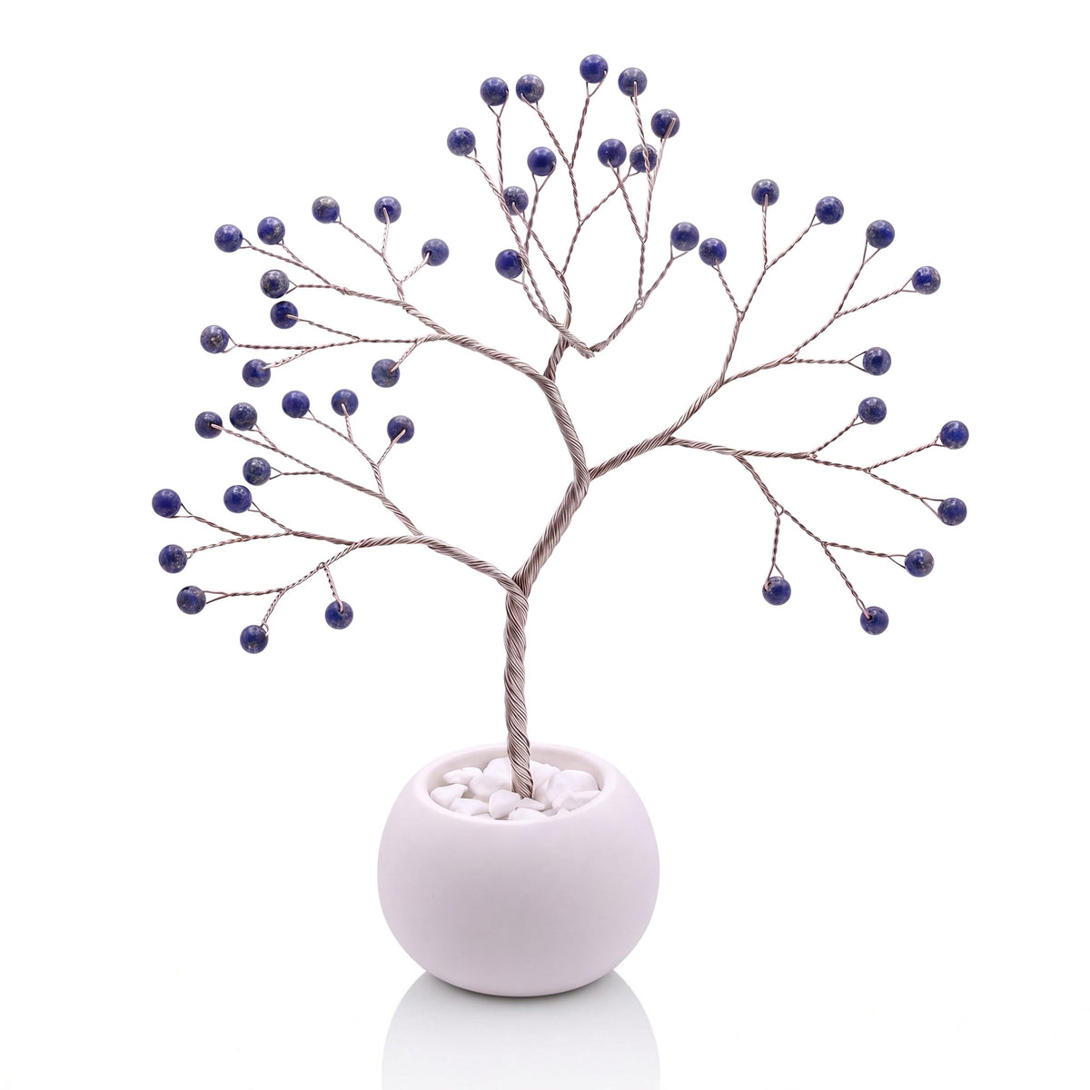 Silver-plated wire tree with polished deep blue lapis lazuli beads in a white bowl with white pebbles