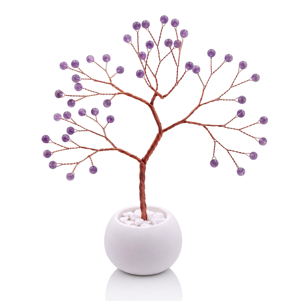 Copper wire tree with polished grape purple amethyst beads in a plain white bowl filled with white pebbles
