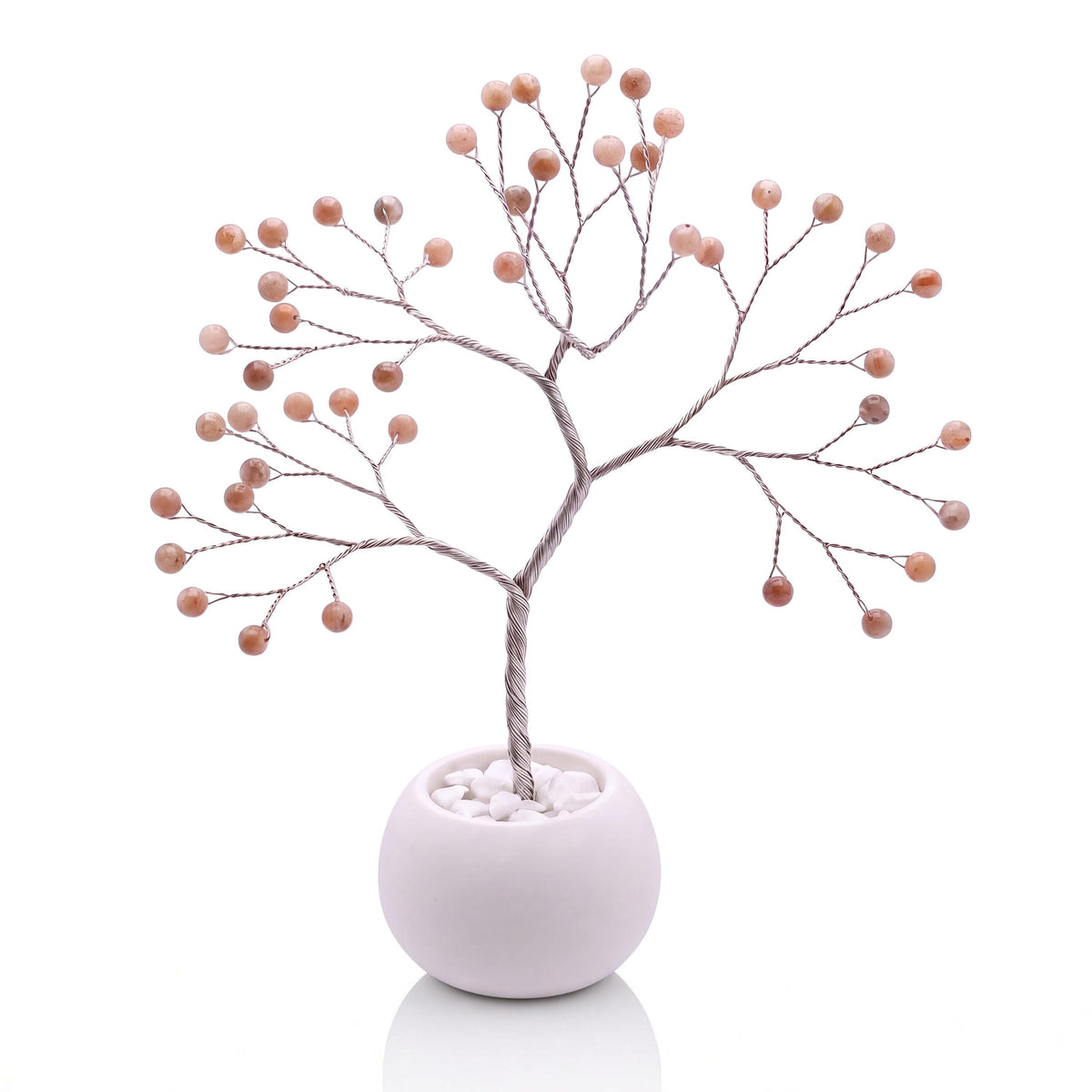 Silver-plated wire tree with polished tangerine orange moonstone beads in a white bowl with white pebbles
