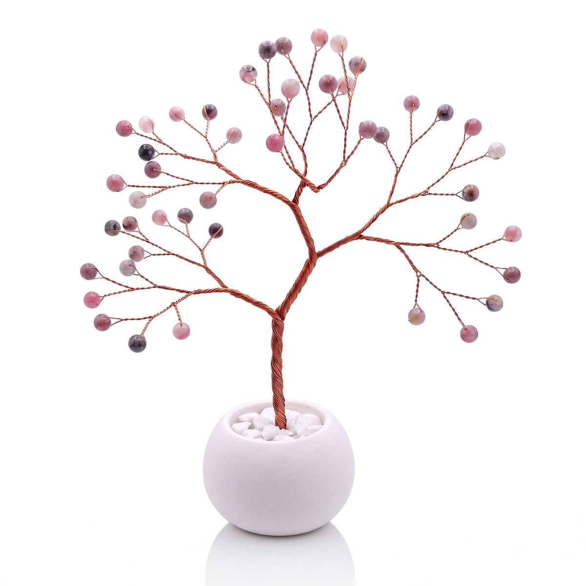 Copper wire tree with polished lingonberry pink thulite beads in a plain white bowl filled with white pebbles