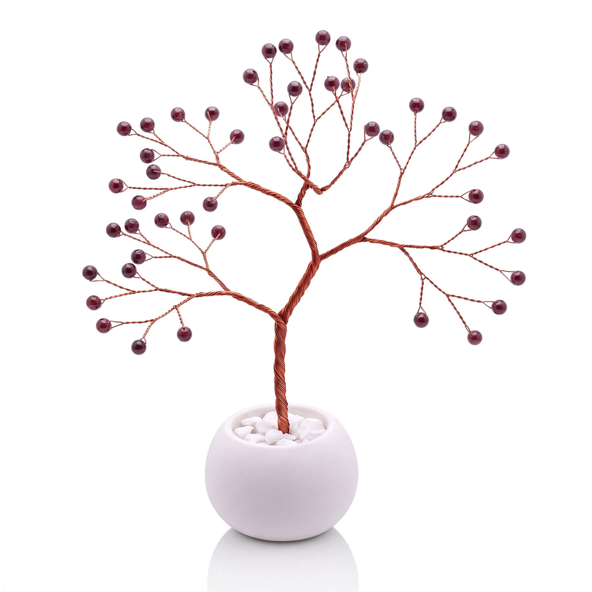 Copper wire tree with polished black cherry red garnet beads in a plain white bowl filled with white pebbles