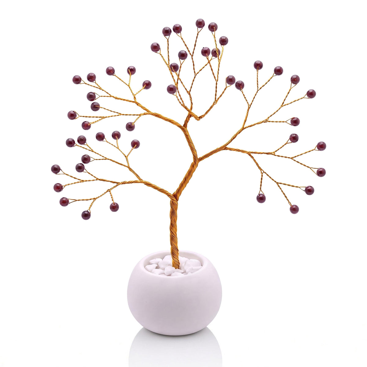 Gold-plated wire tree with polished black cherry red garnet beads in a white bowl with white pebbles