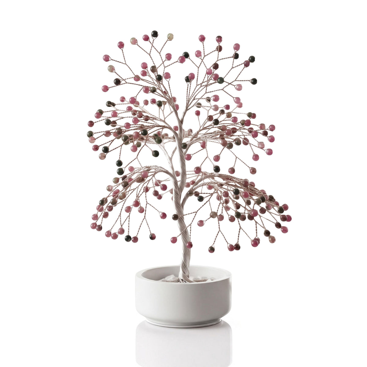 Silver-plated wire tree with polished pink and green watermelon tourmaline beads in a white ceramic bowl