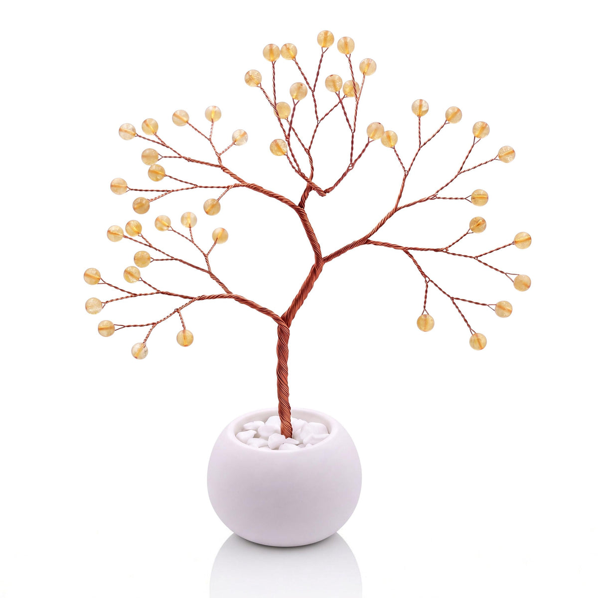 Copper wire tree with polished honey yellow citrine beads in a plain white bowl filled with white pebbles