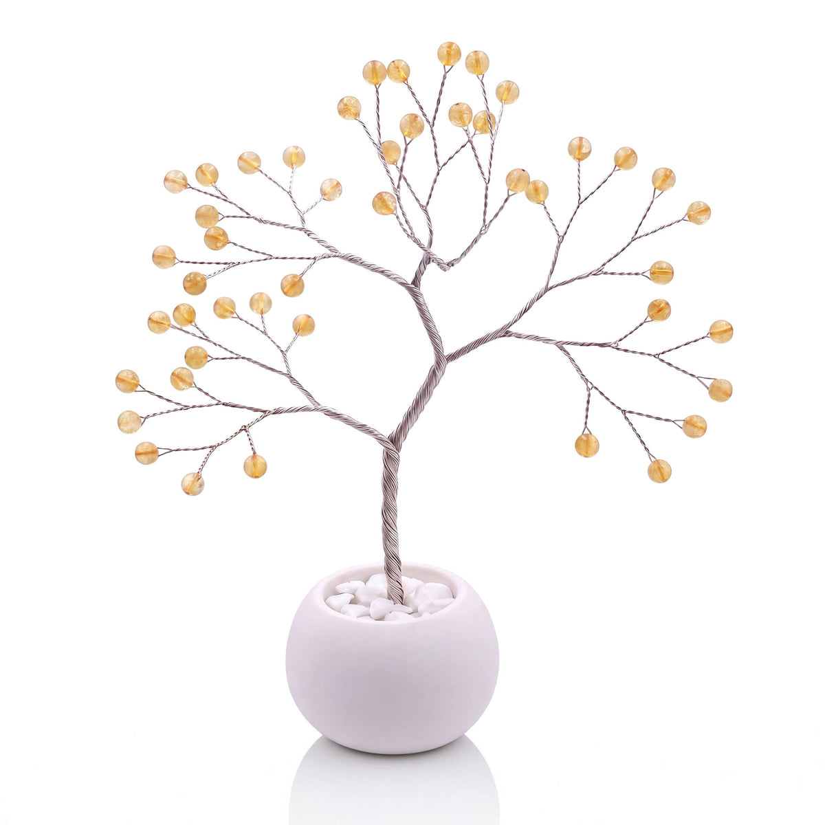 Silver-plated wire tree with polished honey yellow citrine beads in a white bowl with white pebbles