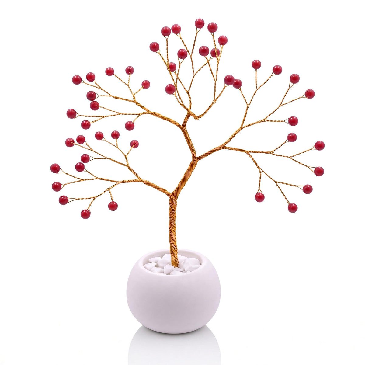 Gold-plated wire tree with polished red coral beads in a white bowl with white pebbles
