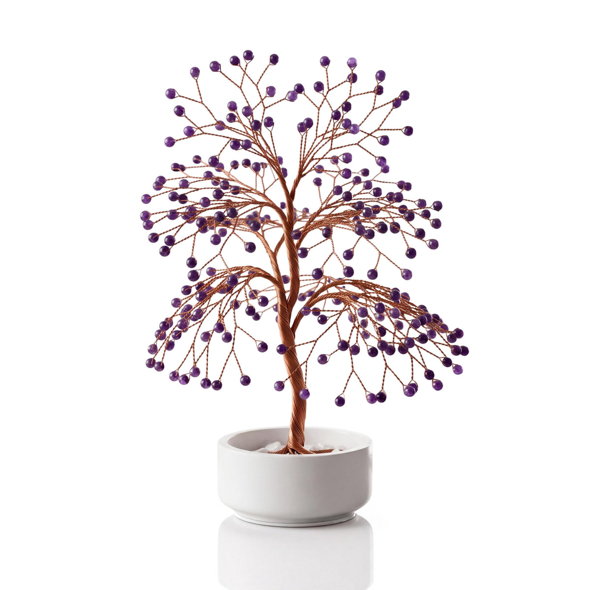 Copper wire tree with polished deep purple amethyst spheres in a plain white ceramic bowl