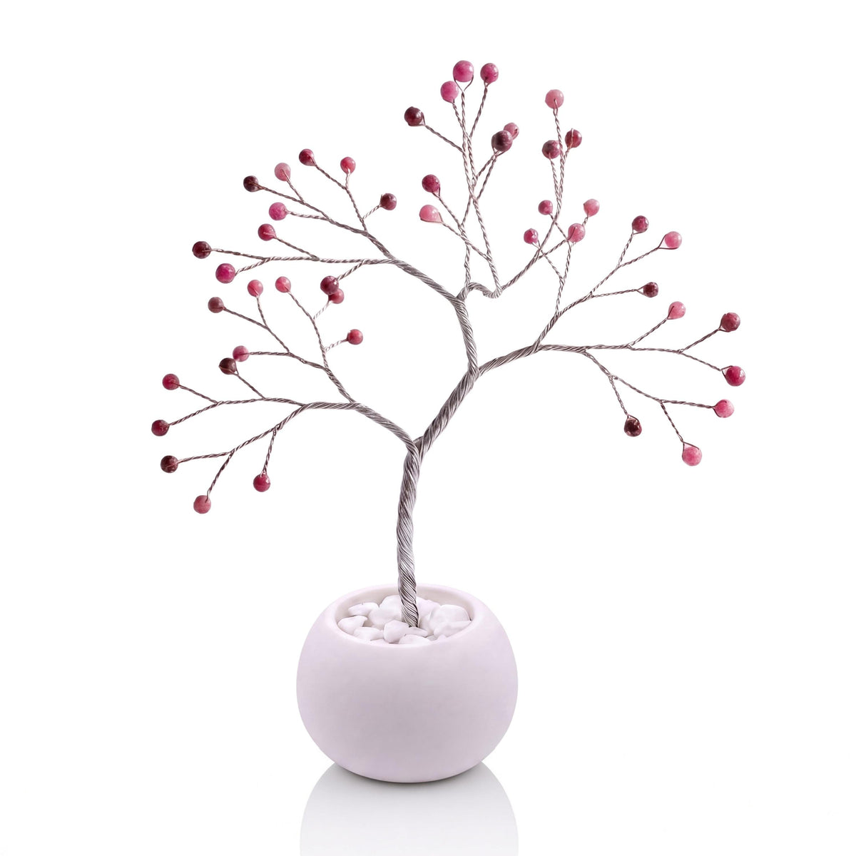 Silver-plated wire tree with faceted ruby beads in a white bowl with white pebbles