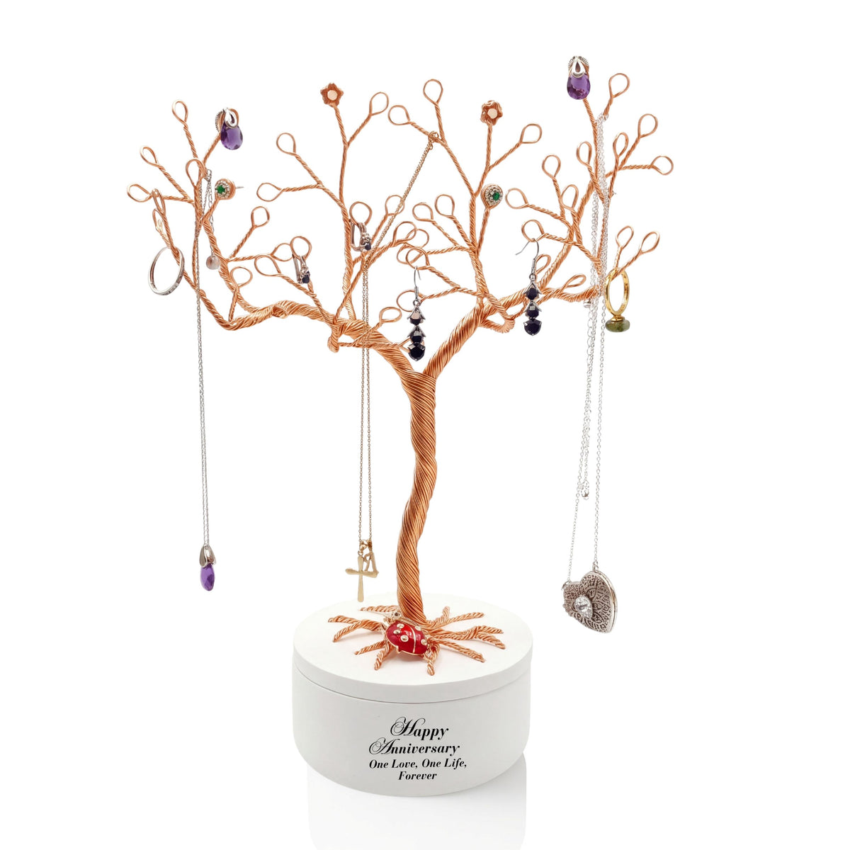Gold wire jewelry tree in a white lidded anniversary bowl with necklaces and earrings