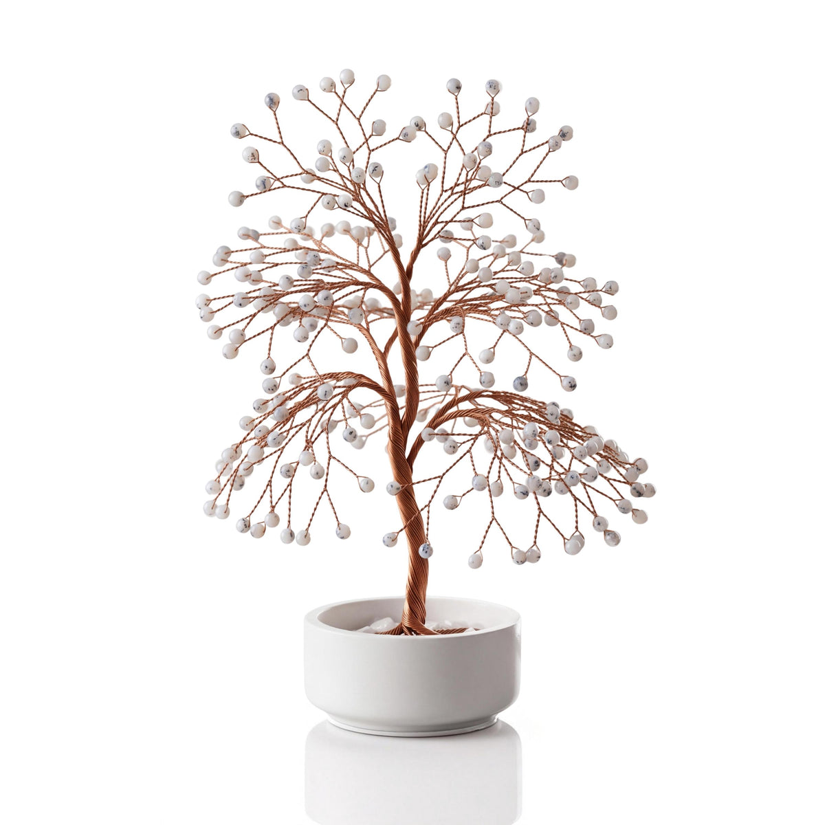 Copper wire tree with polished milky white dendritic opal spheres in a plain white ceramic bowl