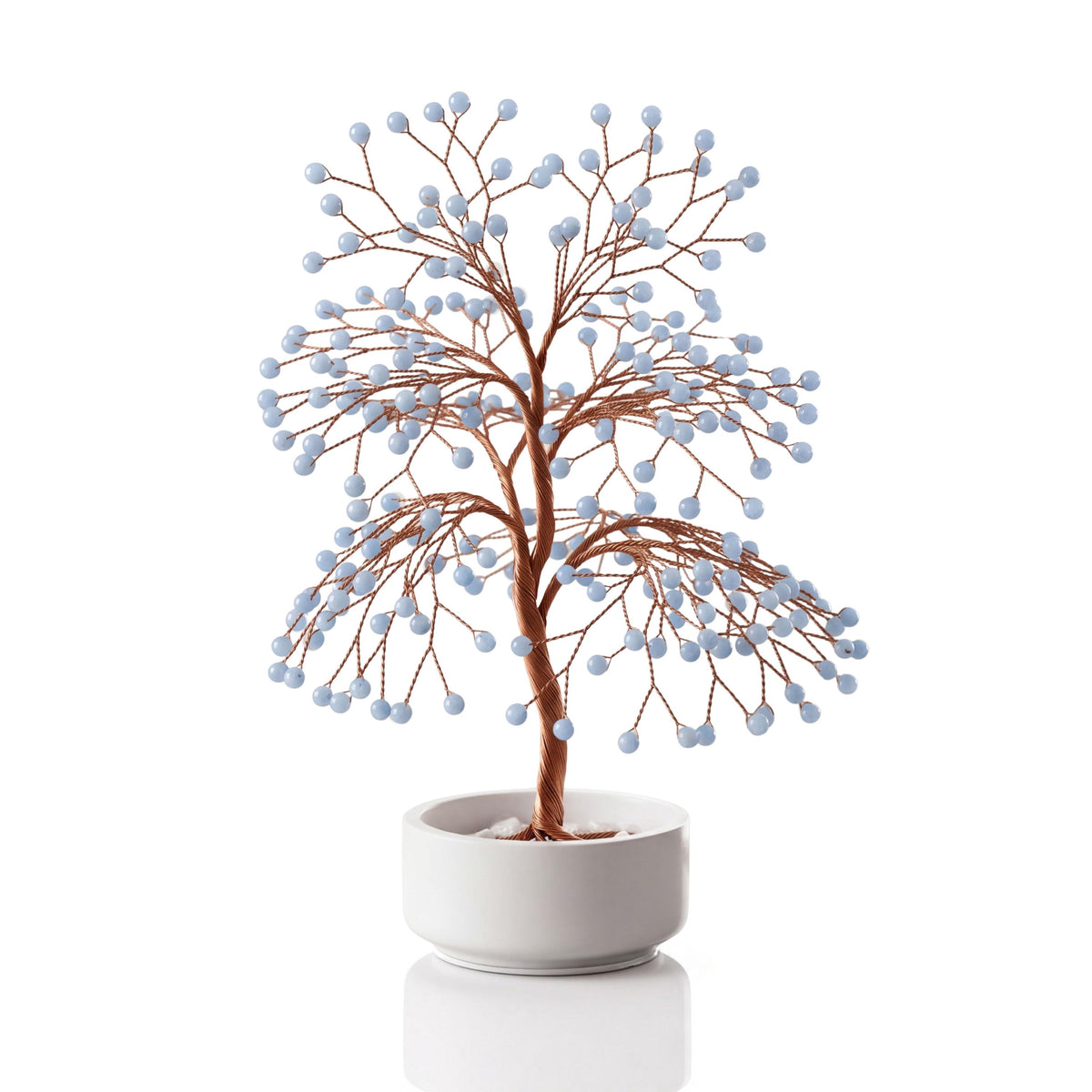 Copper wire tree with polished pale sky blue angelite spheres in a plain white ceramic bowl