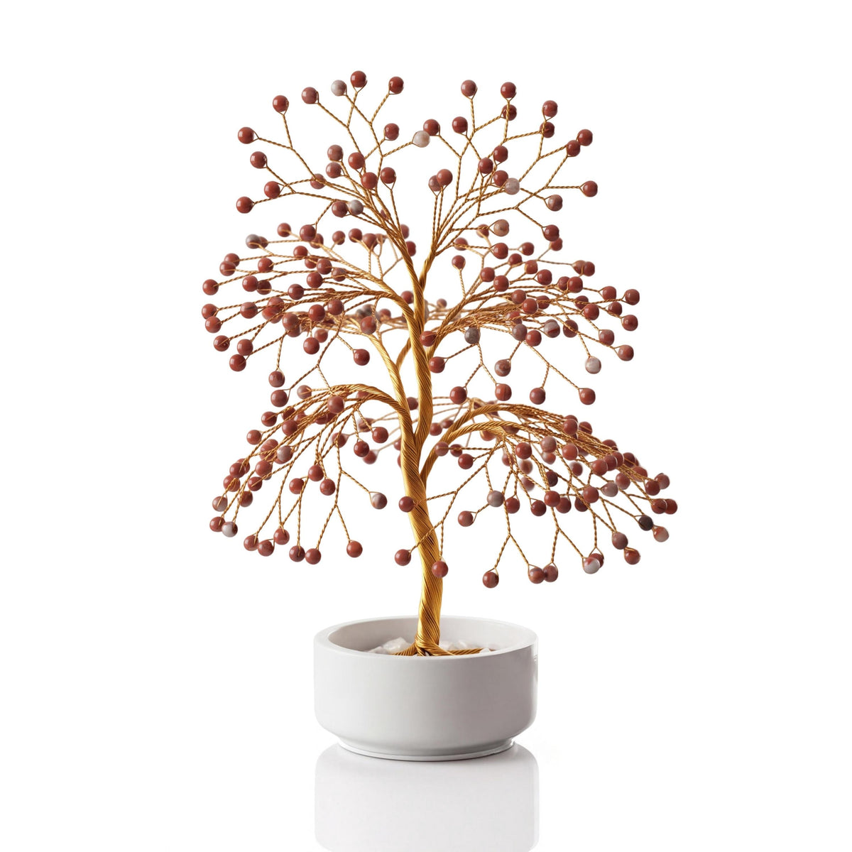 Gold-plated wire tree with polished brick red and cream red jasper spheres in a white ceramic bowl