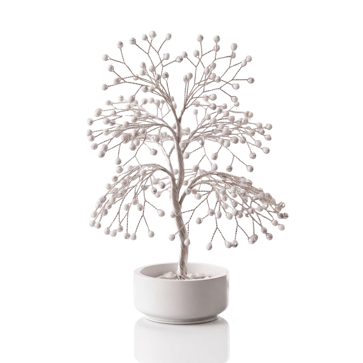 Silver-plated wire tree with polished white howlite beads with grey marbling in a white ceramic bowl