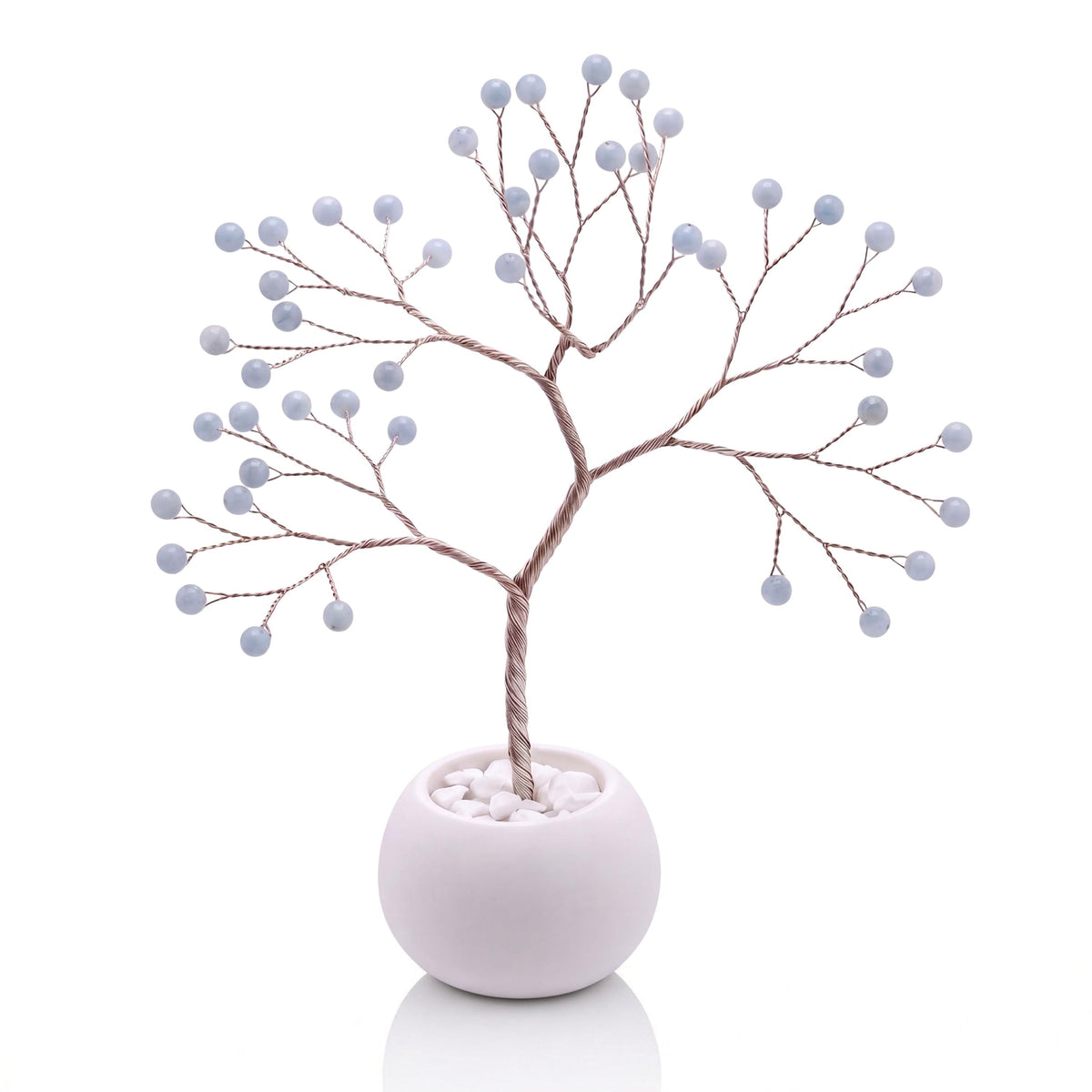 Silver-plated wire tree with polished powder blue angelite beads in a white bowl with white pebbles