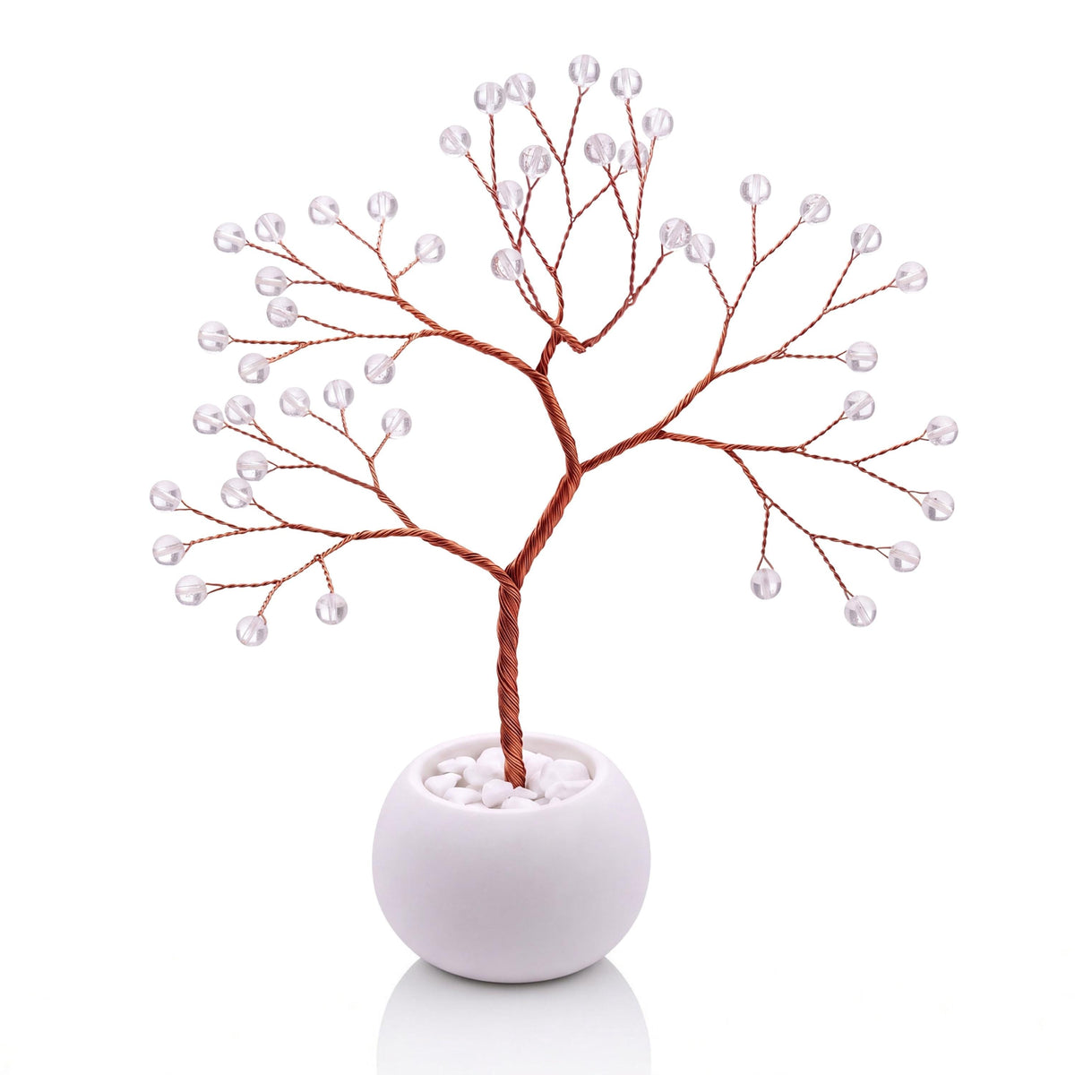 Copper wire tree with polished clear quartz beads in a plain white bowl filled with white pebbles