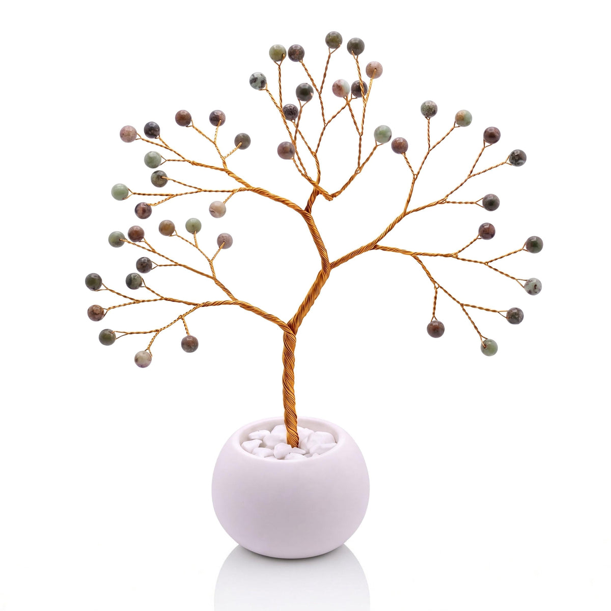 Gold-plated wire tree with polished pistachio green opal beads in a white bowl with white pebbles