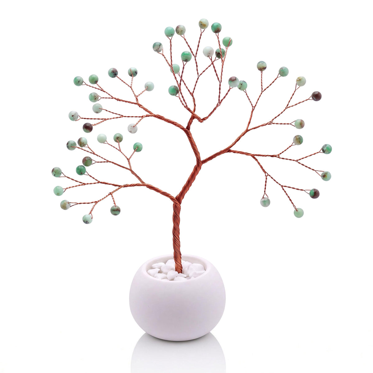 Copper wire tree with polished apple green chrysoprase beads in a plain white bowl filled with white pebbles