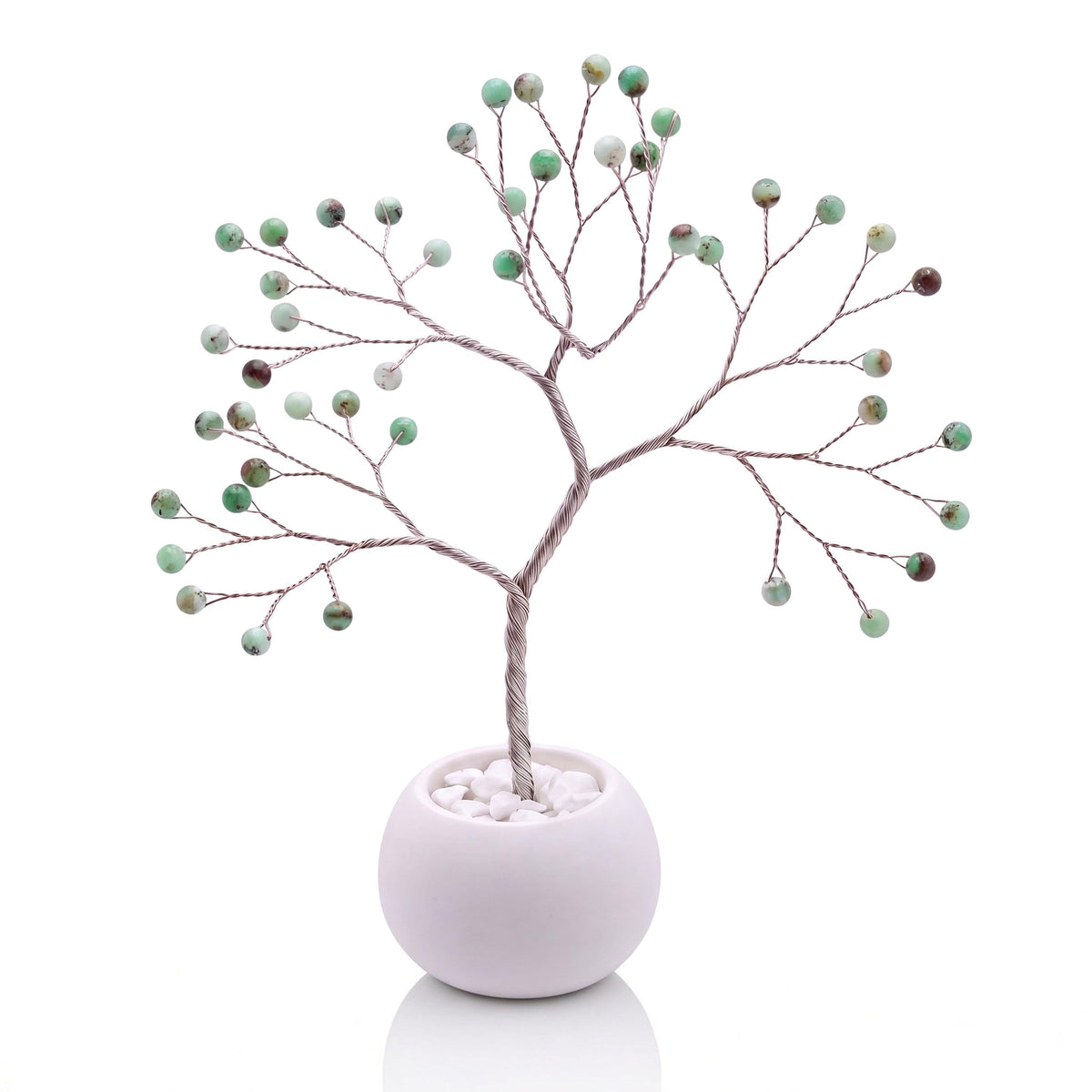 Silver-plated wire tree with polished apple green chrysoprase beads in a white bowl with white pebbles