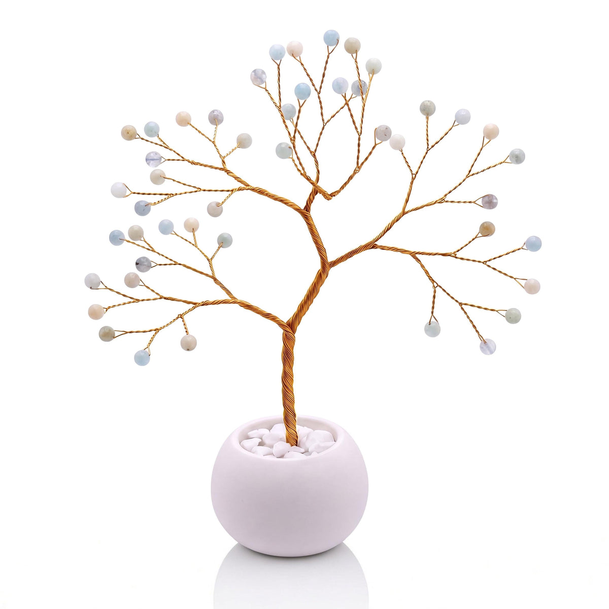 Gold-plated wire tree with polished milky sea blue aquamarine beads in a white bowl with white pebbles